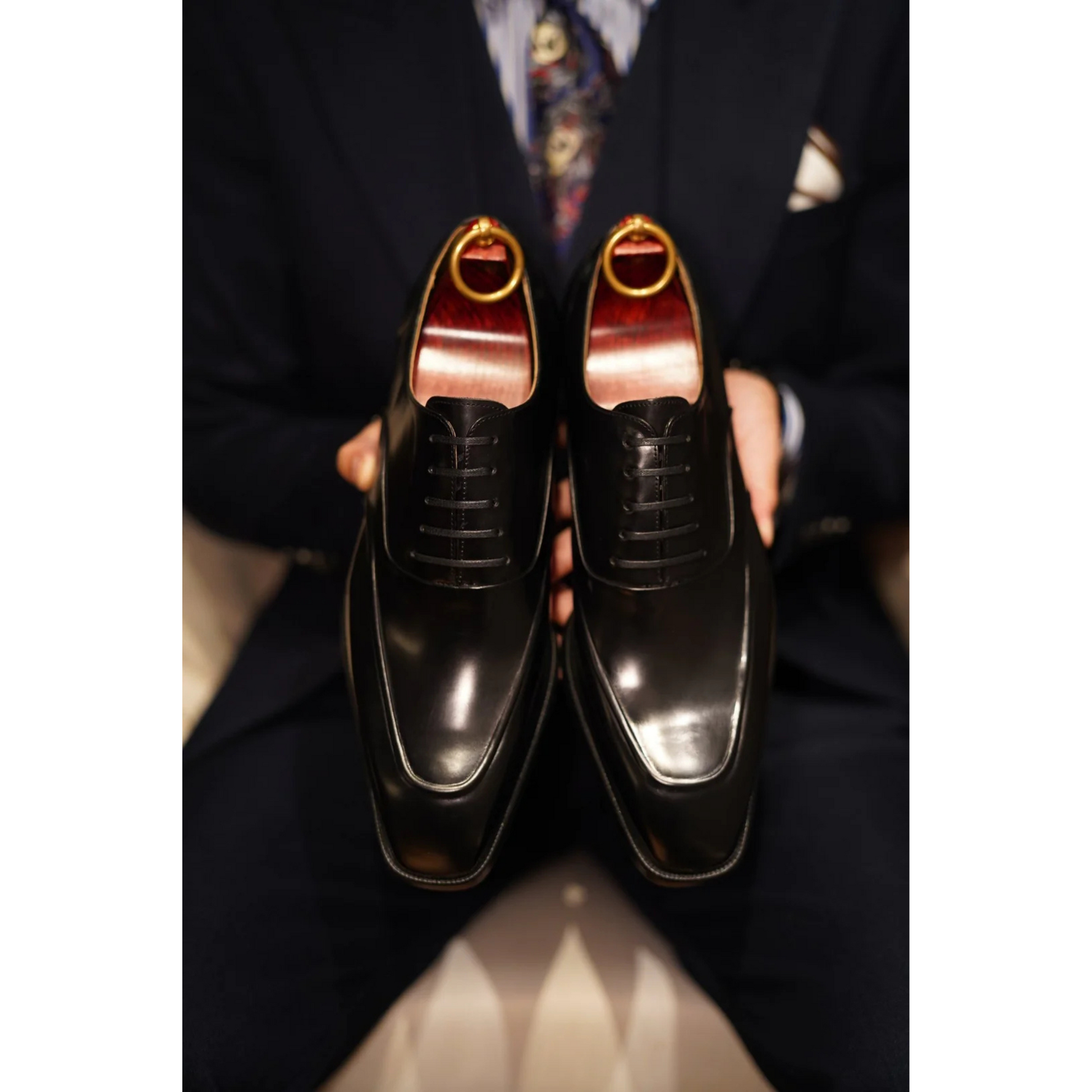 Front view of Black Wholecut Oxford Shoes, highlighting the polished high-gloss finish and elegant lace-up design for a formal look.