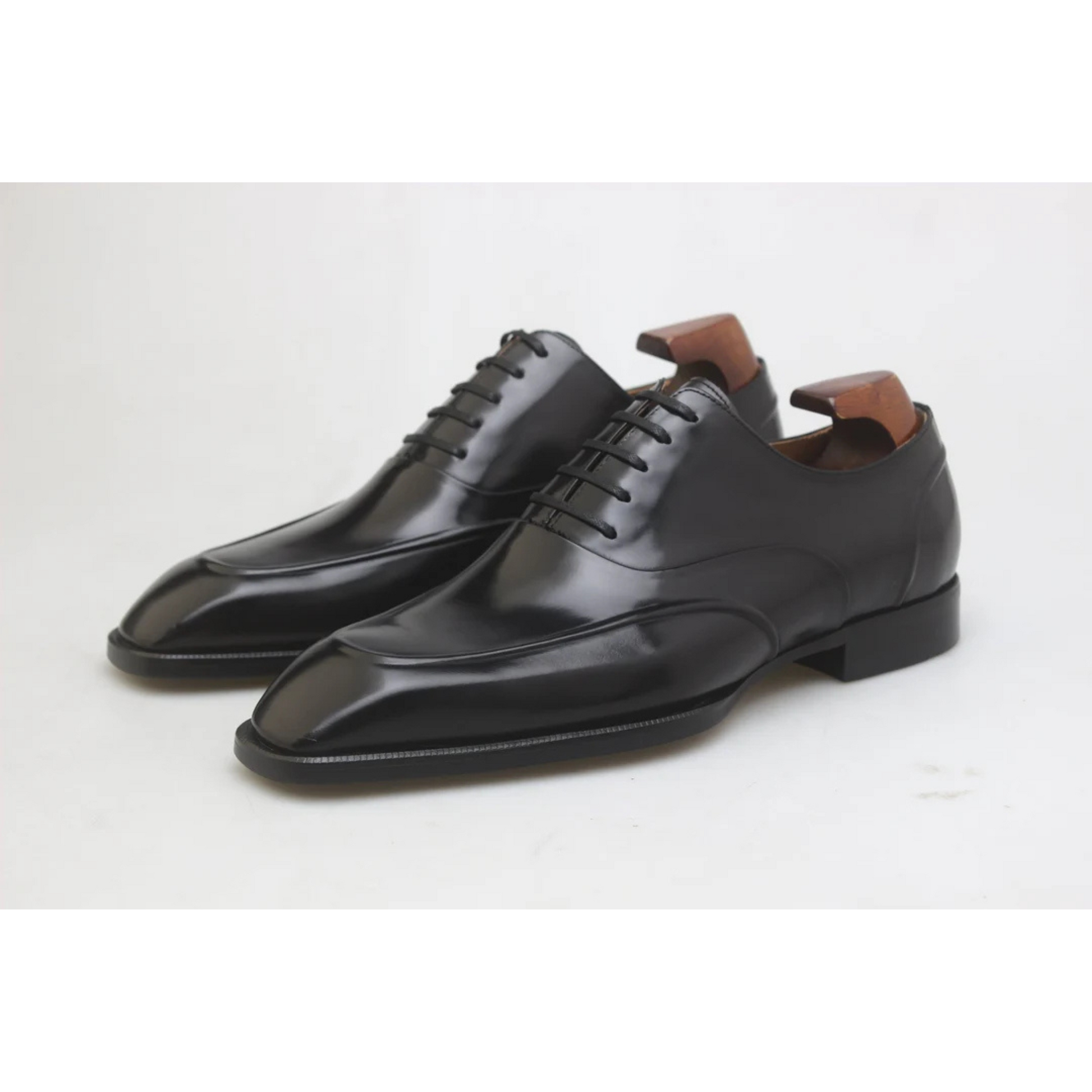 Premium finish of Black Wholecut Oxford Shoes, showcasing high-gloss leather, smooth surface, and sleek design ideal for formal occasions.