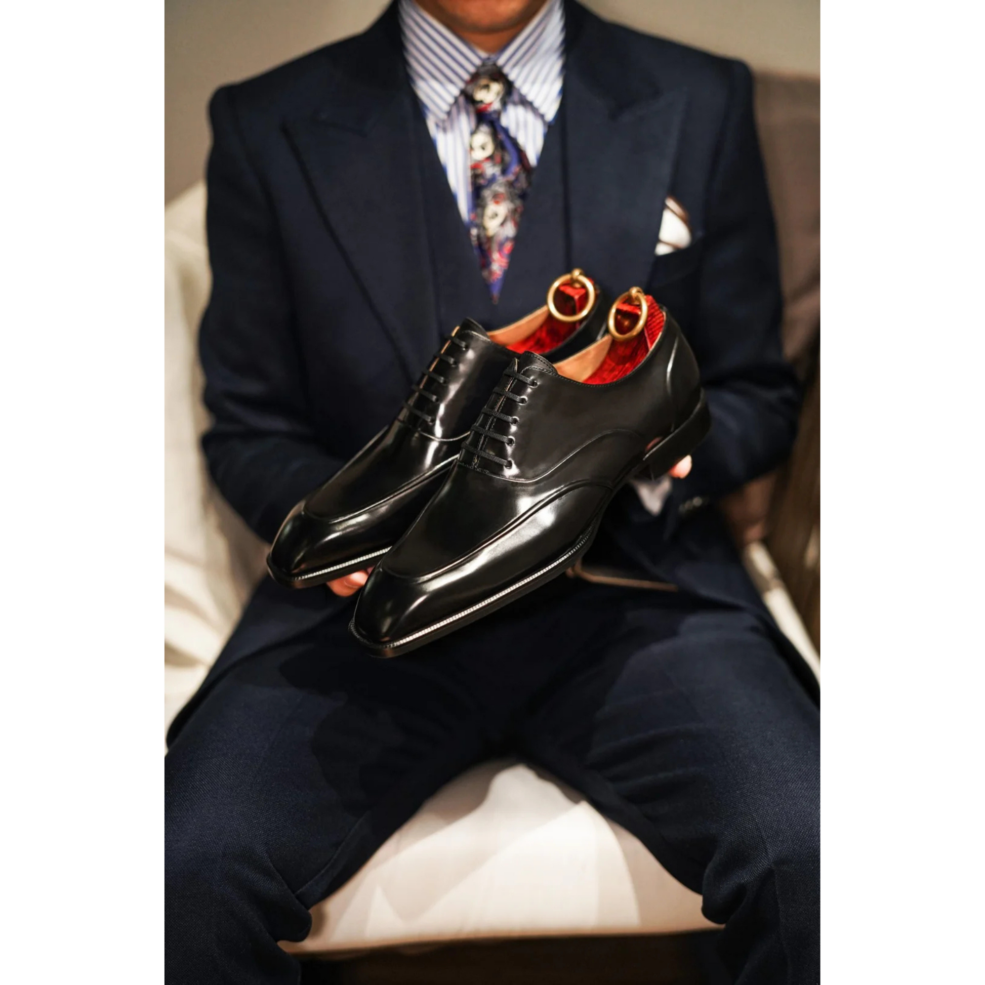 Black Wholecut Oxford Shoes with a high-gloss finish, worn with formal trousers, showcasing sleek design and premium craftsmanship.