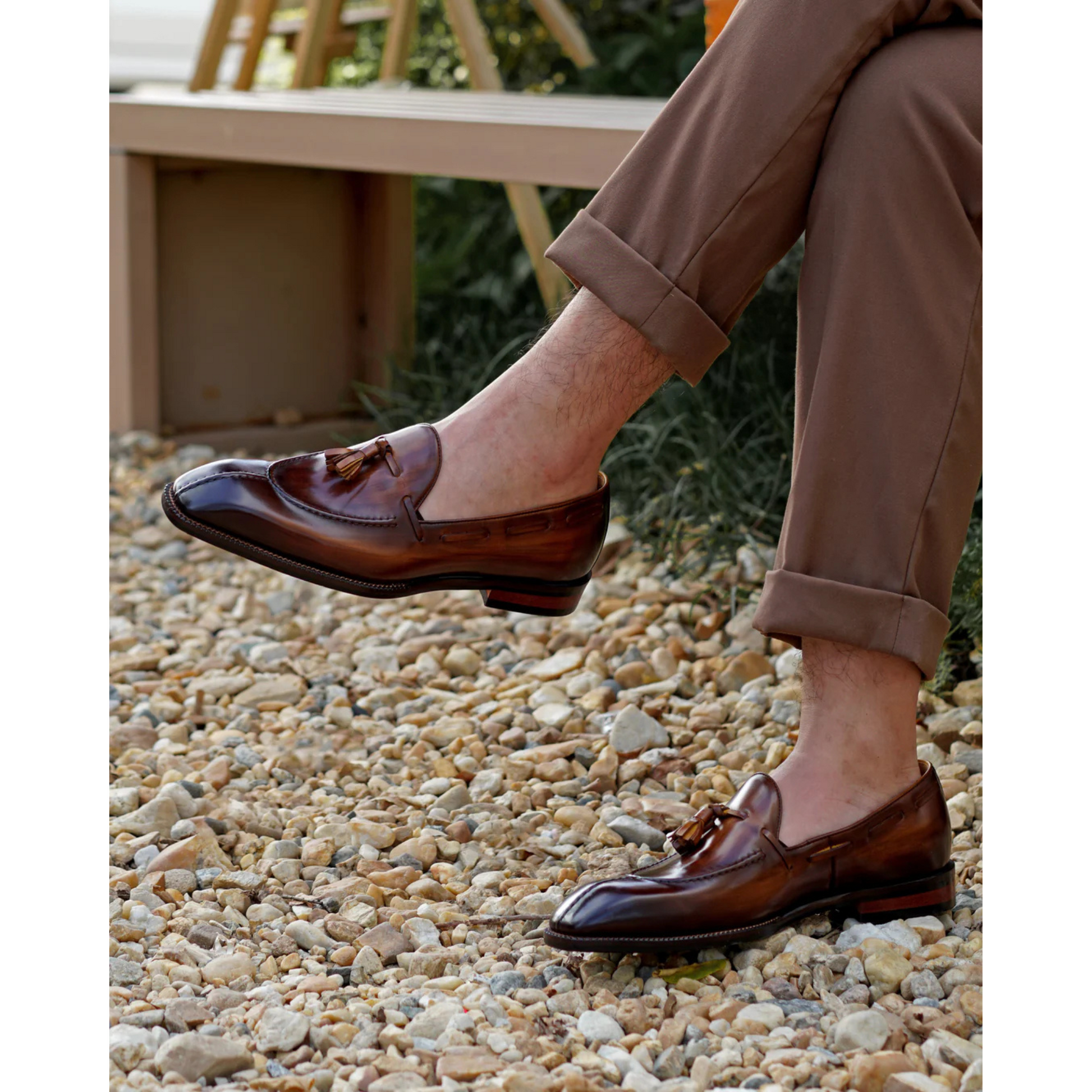 Brown Patina Leather Tassel Loafers worn outdoors with rolled-up trousers, showcasing the polished leather, stylish tassels, and a comfortable fit in a natural setting.