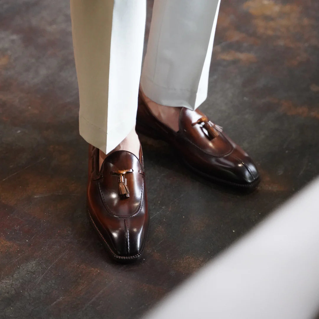 Brown Patina Leather Tassel Loafers worn with tailored beige trousers, showcasing the elegant craftsmanship, polished finish, and stylish tassel detail.