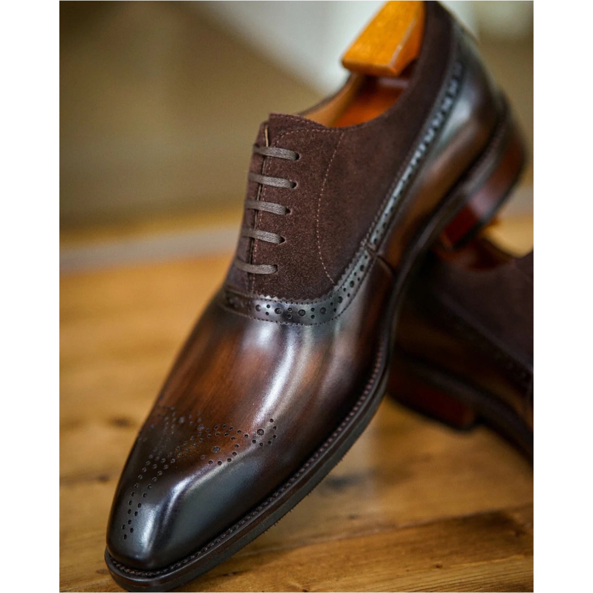 Close-up of premium brown leather oxford shoes with suede detailing and intricate brogue patterns, offering a sophisticated look.