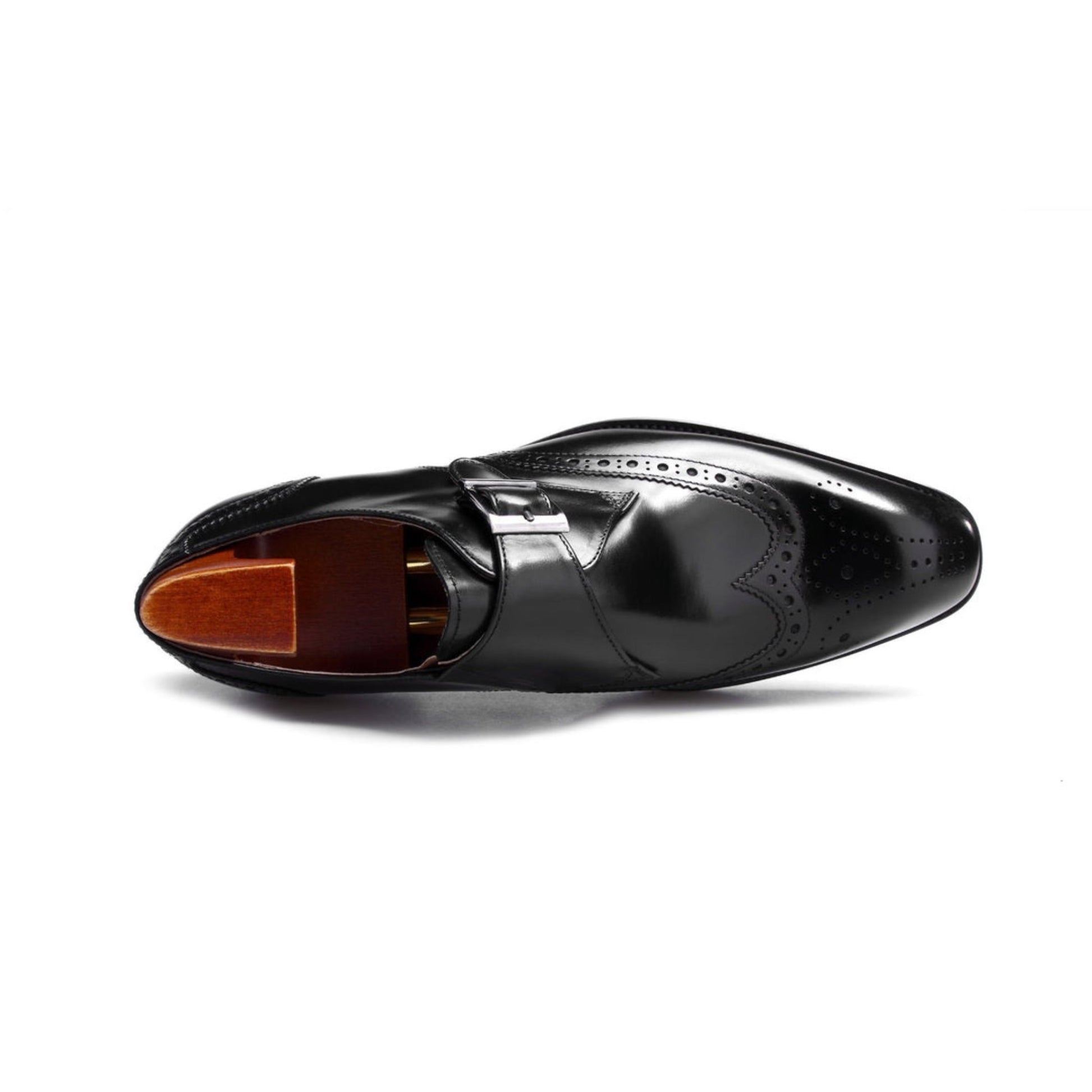 Close-up of black leather single monk strap shoes showcasing intricate brogue detailing and polished leather.