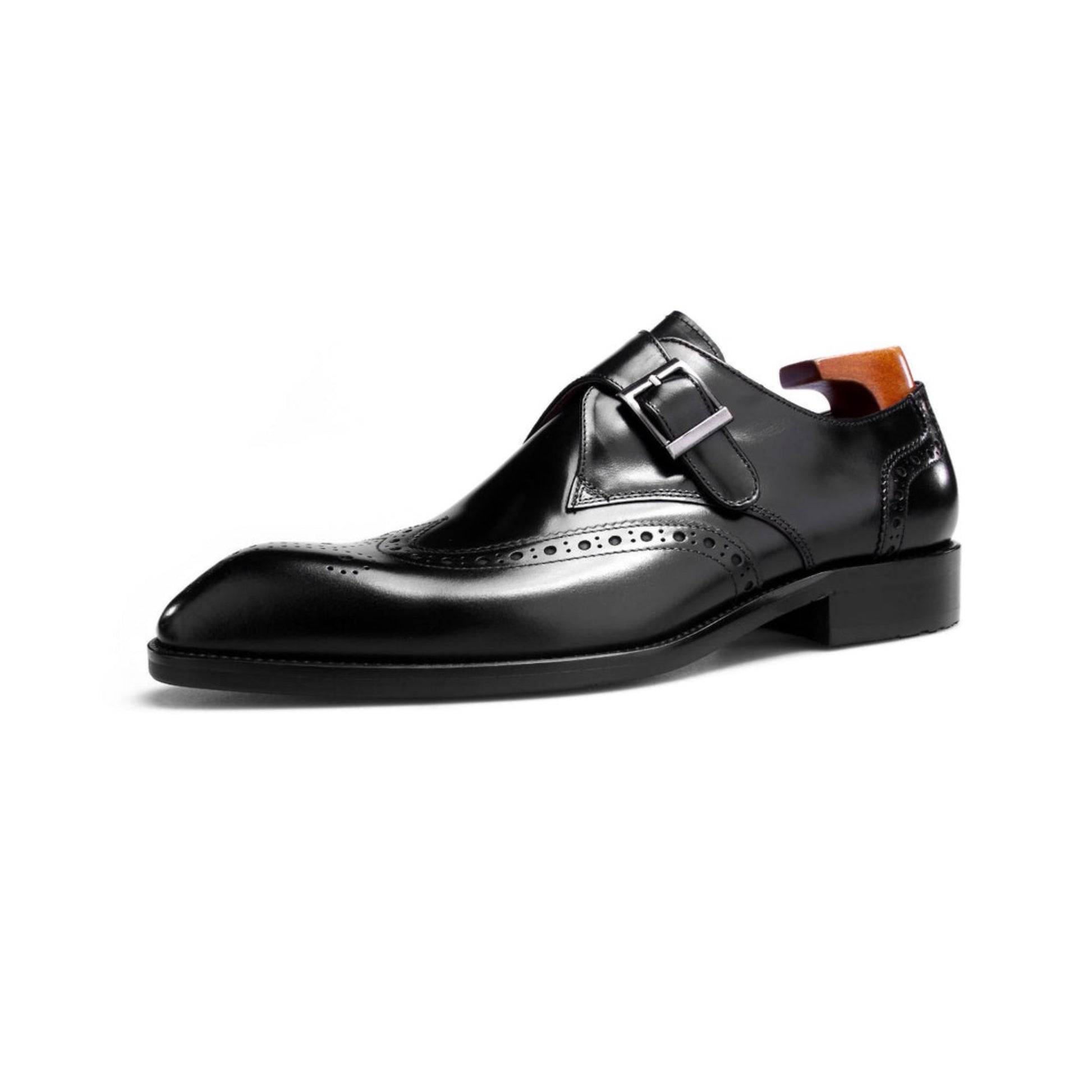 Profile view of black leather single monk strap shoes with classic brogue design and shiny finish.
