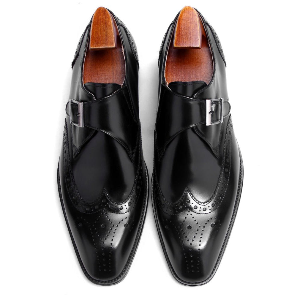 Top view of black leather single monk strap shoes featuring brogue design and metal buckle.